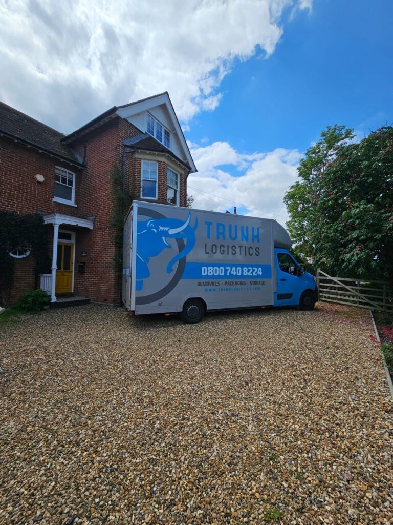 Removals truck parked outside large house during residential move in the UK