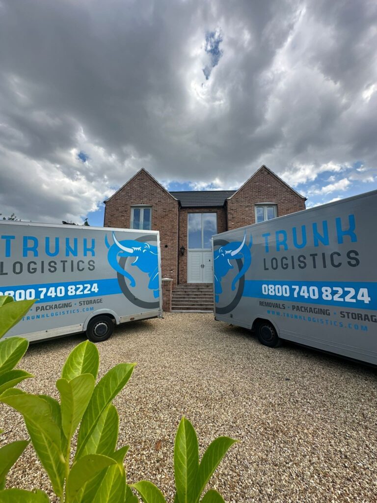 Two removals trucks outside large house during residential move