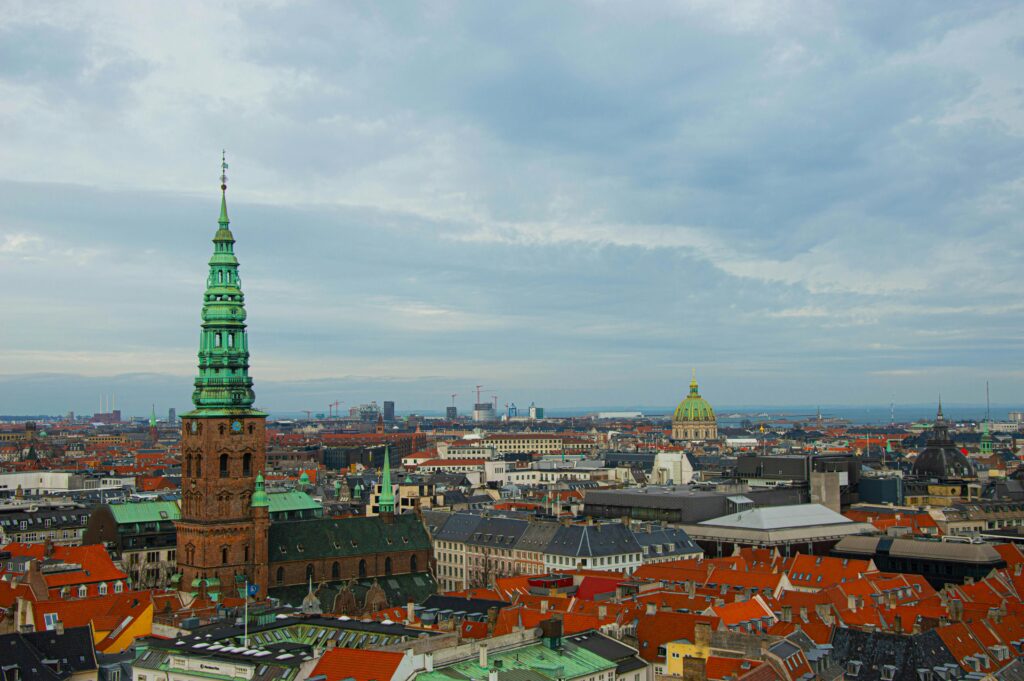 Aerial view of Copenhagen cityscape with green church spire and Frederik's Church dome across the rooftops — UK to Denmark removals to Copenhagen by Trunk Logistics