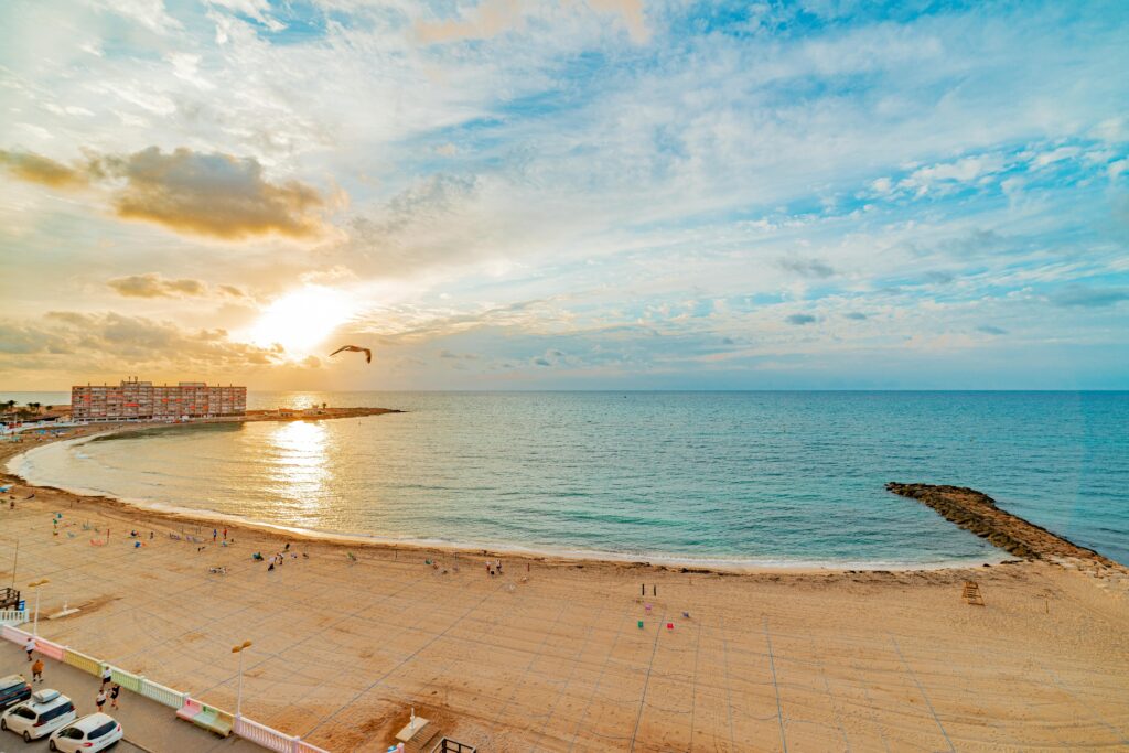 Aerial view of Costa Blanca sandy beach at sunset with calm Mediterranean sea — UK to Spain removals to the Costa Blanca and Alicante region by Trunk Logistics