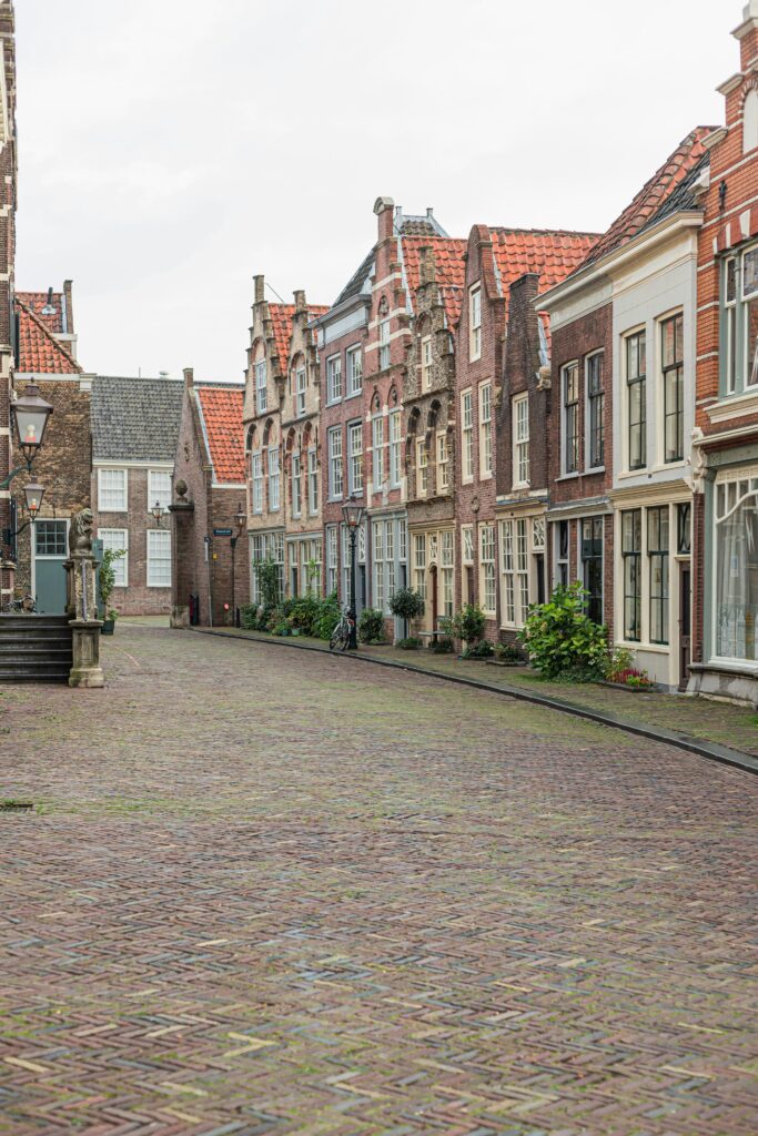 Quiet cobbled street lined with traditional Dutch brick gabled houses — UK to Netherlands removals to cities and towns across the Netherlands by Trunk Logistics