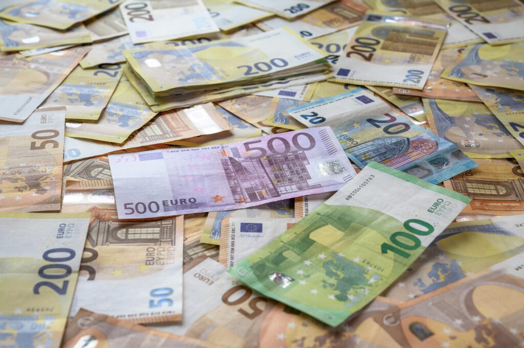 Mixed euro banknotes including 500, 200, 100, 50 and 20 euro notes spread across a surface — duty-free Transfer of Normal Residence customs relief for UK to Europe household removals