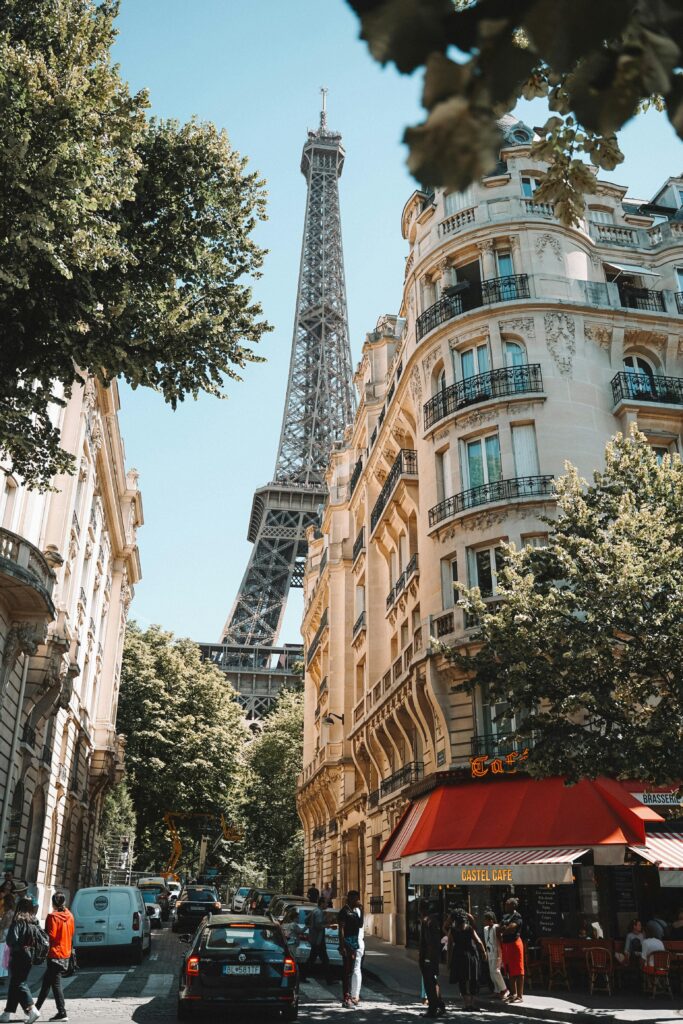 Paris street scene with Eiffel Tower visible above Haussmann buildings and Castel Cafe — UK to France removals to Paris and all French regions by Trunk Logistics