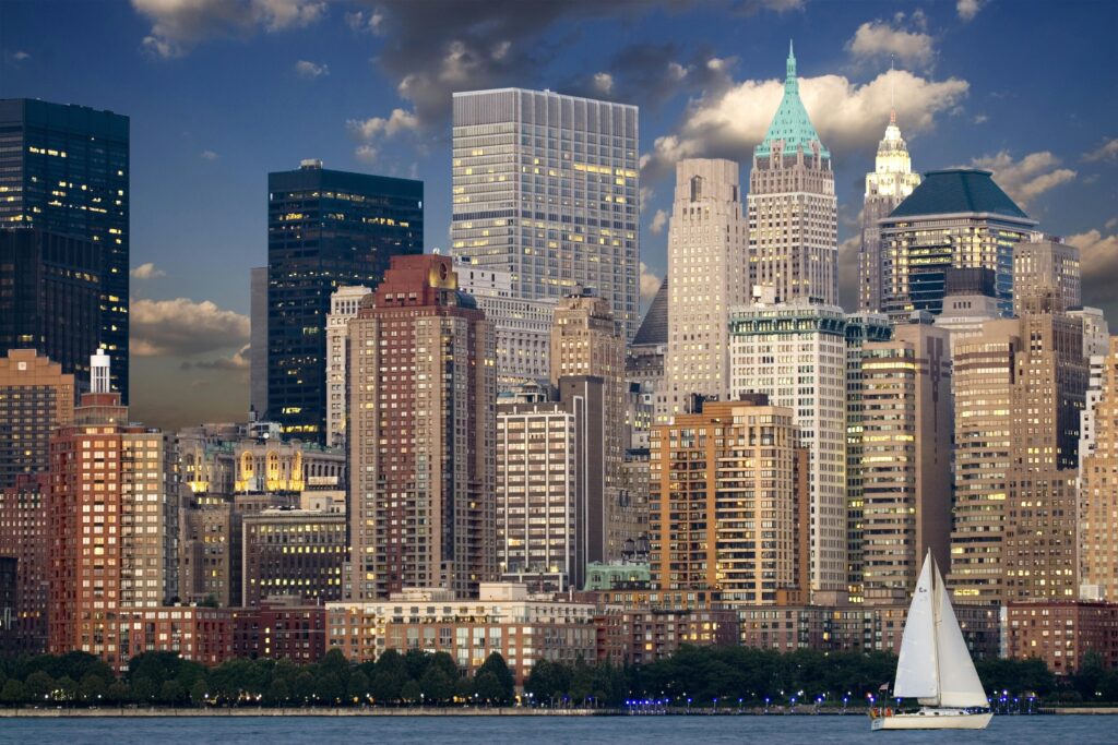 New York City Manhattan skyline viewed from the water with a sailing boat in the foreground — destination image for Trunk Logistics UK to USA international removals guide
