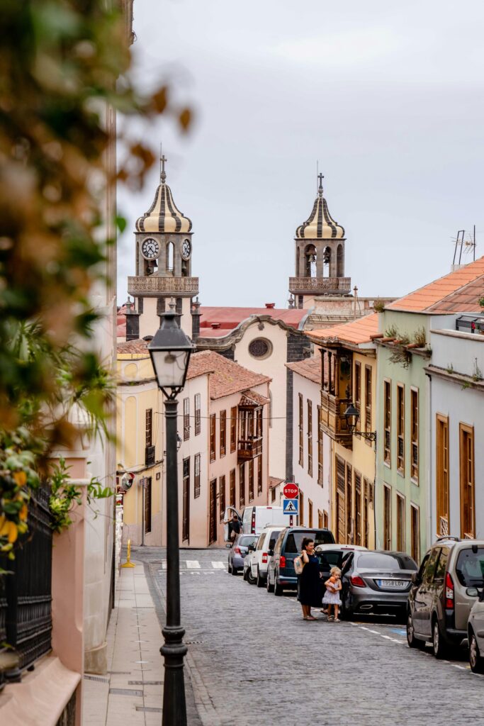 Cobbled street in La Laguna Tenerife with distinctive striped church clock towers — UK to Spain Canary Islands removals to Tenerife by Trunk Logistics