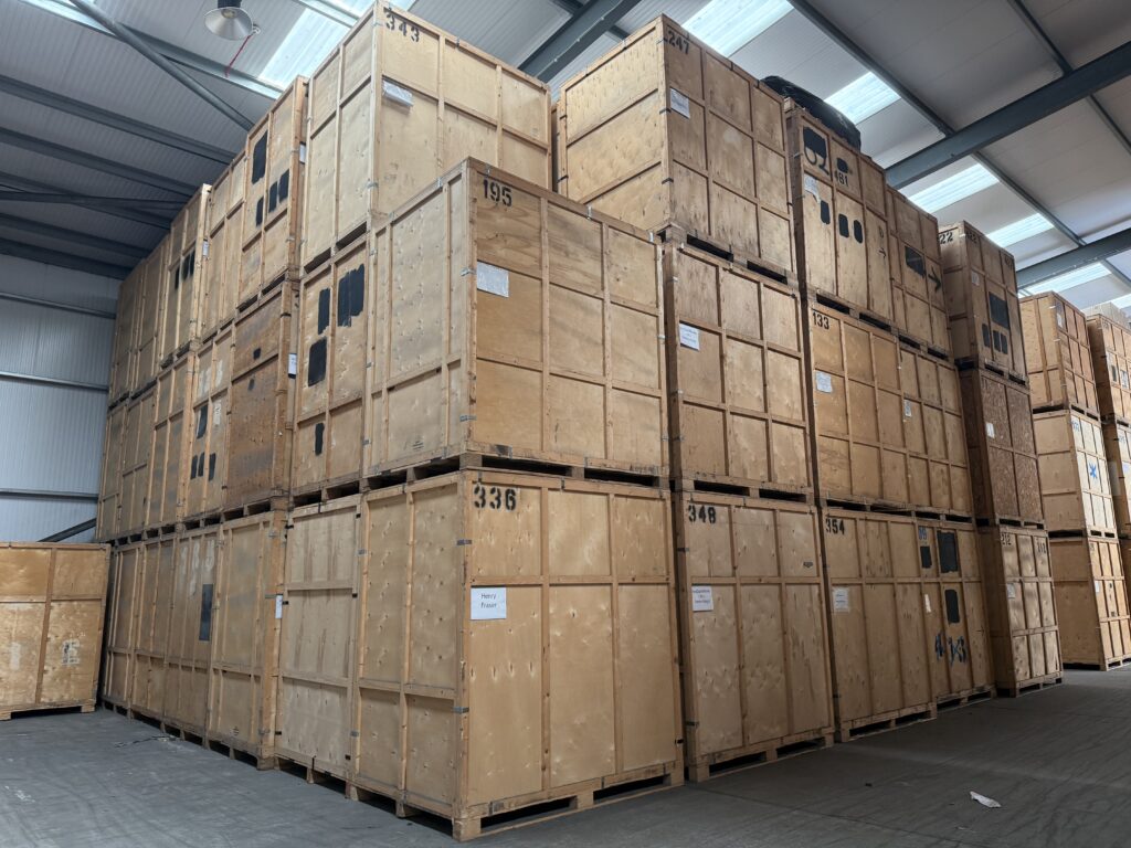 Close-up of stacked numbered and labelled wooden storage crates inside Trunk Logistics managed warehouse in Essex — organised crate storage for house moves and removals