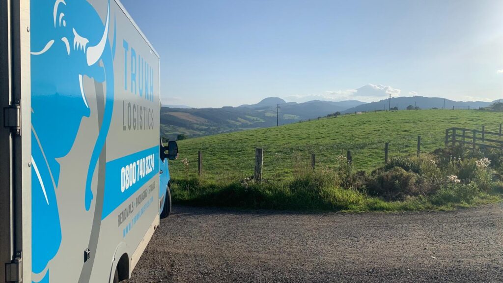 Trunk Logistics removal van parked on a rural Irish lane with green rolling hills and mountains in the background — Ireland to UK removals service